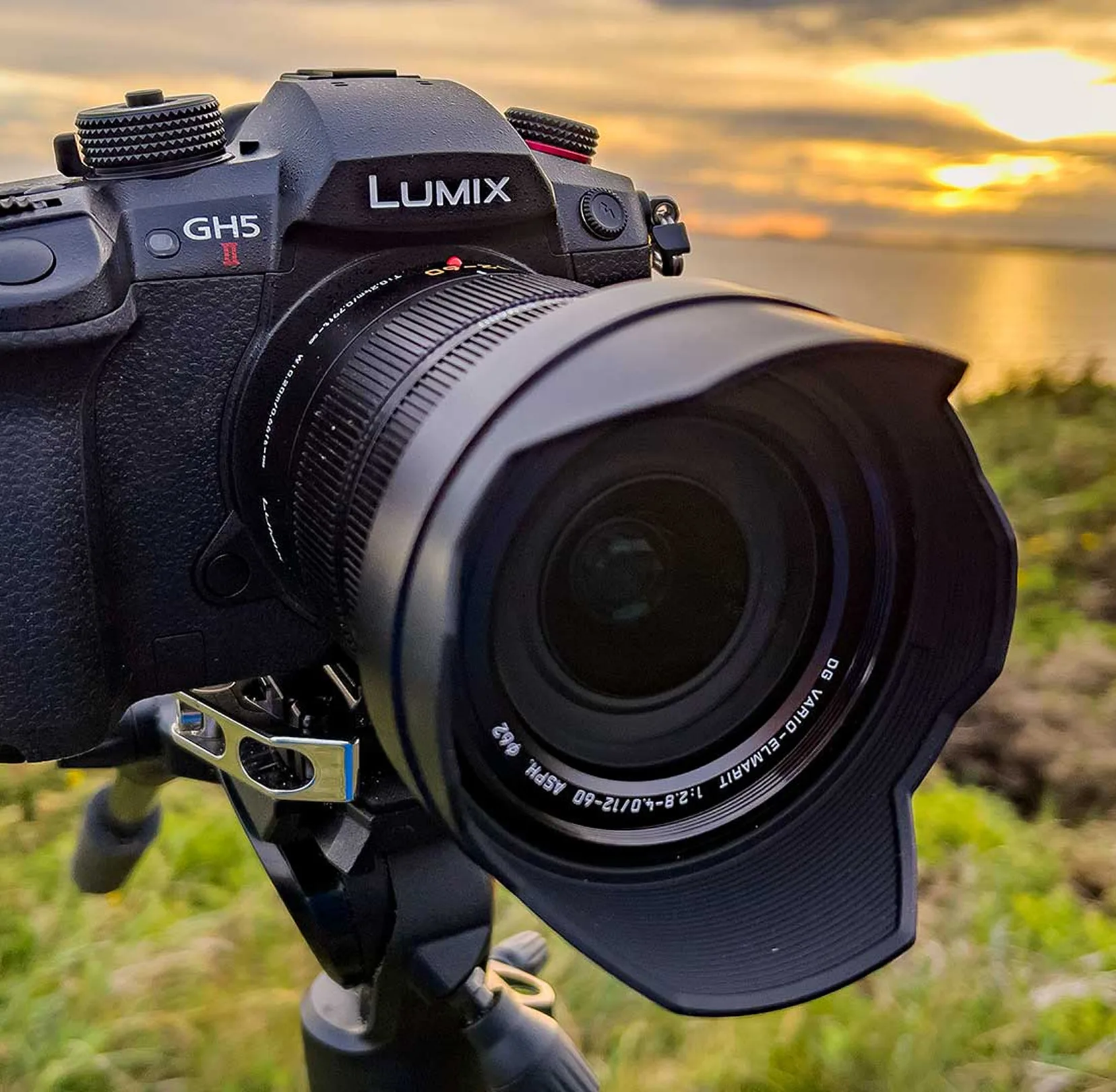 Spiegellose Kamera auf Stativ vor Sonnenuntergang mit Blick auf Landschaft.